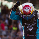 A photo of Sébastien Buemi pointing to his helmet after winning a race.